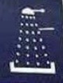 white depiction of what looks very much like a Darlek. There is a rounded top with a stick pointing right, three dotted lines in a triangular shape expanding from the top. Midway down there is another stick pointing right. The bottom is drawn like a bracket symbol turned at 90 degrees. 