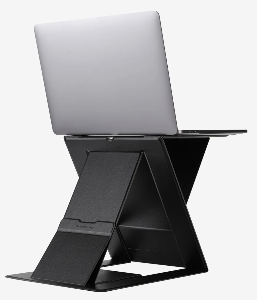 Laptop sitting on a black MOFT folding stand. The stand is setup to the maximum height the product can reach. 